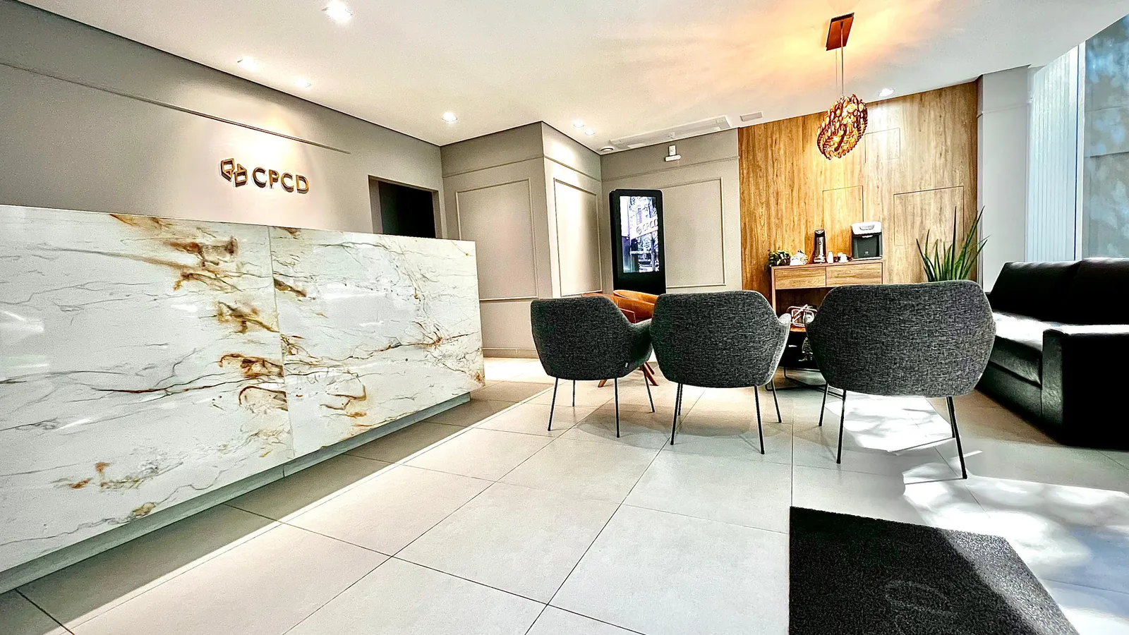 Recepção do CPCD com balcão de mármore e logo na parede
