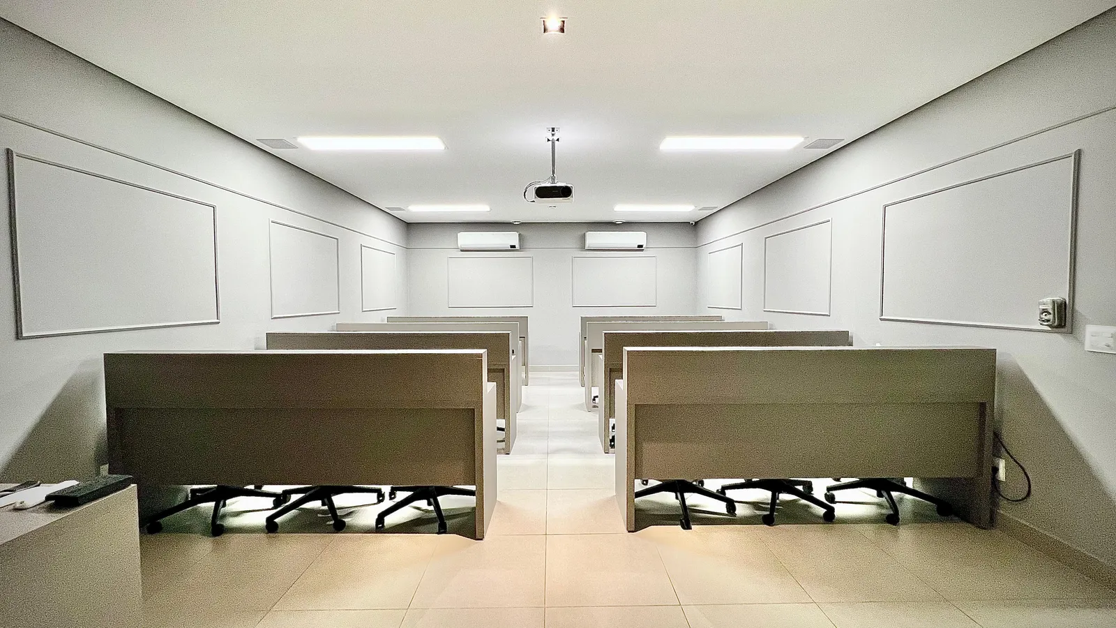 Sala de aula do CPCD com bancadas, cadeiras e projetor